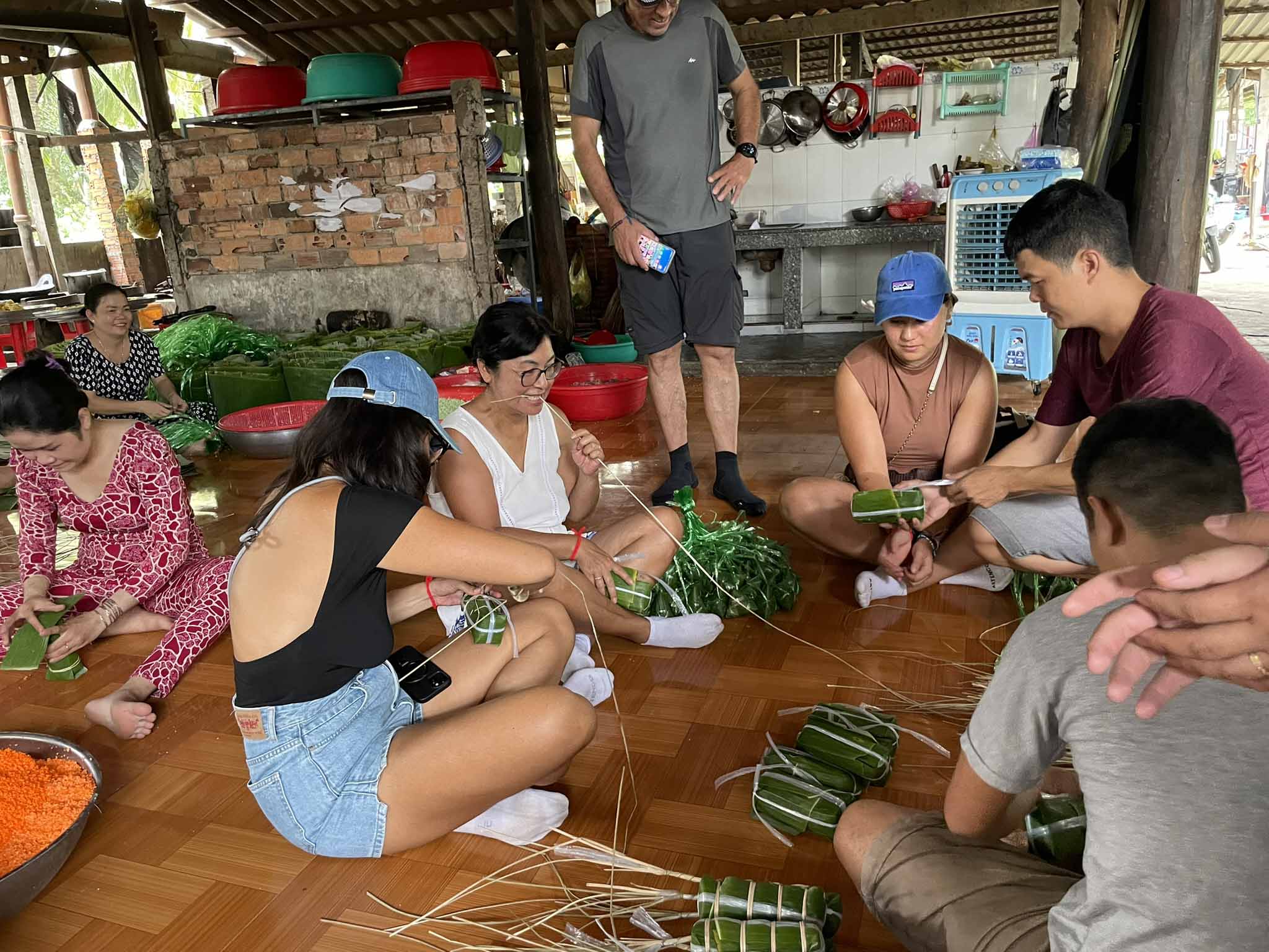 Family making traditional rice cakes with locals in the Mekong Delta