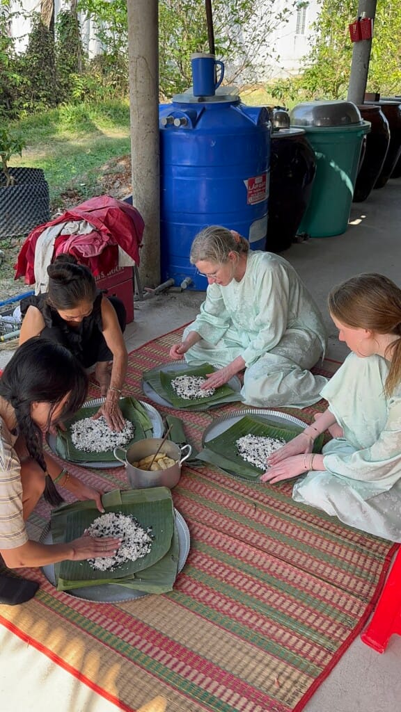 Guests wrapping traditional cakes with a local family